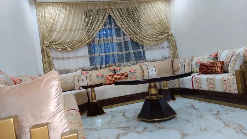 صالون مغربي كريمي بوسائد وردية وطاولة منخفضة