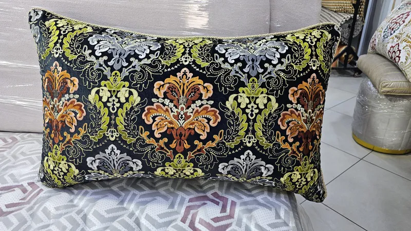 وسادة مطرزة سوداء بزخارف برتقالية وخضراء